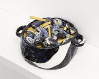 a bowl of mussels sitting on top of a white shelf