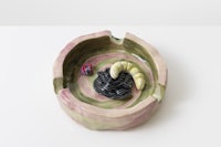 a ceramic ashtray with a spider in it